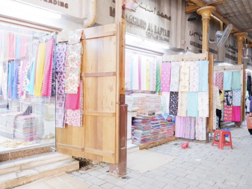 Lamps, scarves, and spices lining a souk market in Dubai