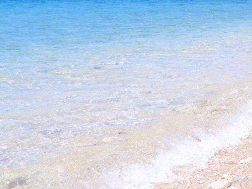 Crystal-clear water lapping the shore at Ilot Canard